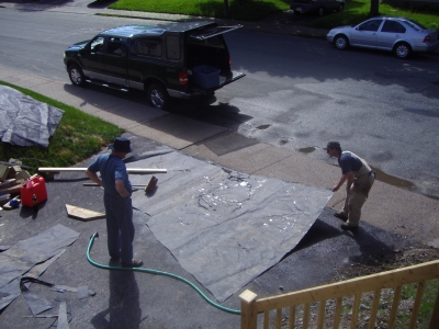 Two guys spreading out wet rubber.